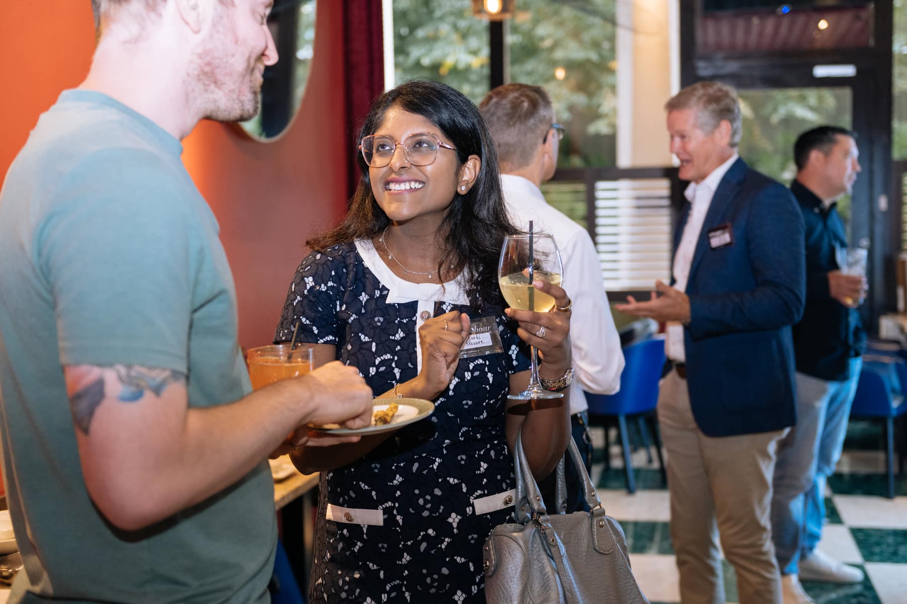 A guest with a drink in conversation at the AI Happy Hour in London