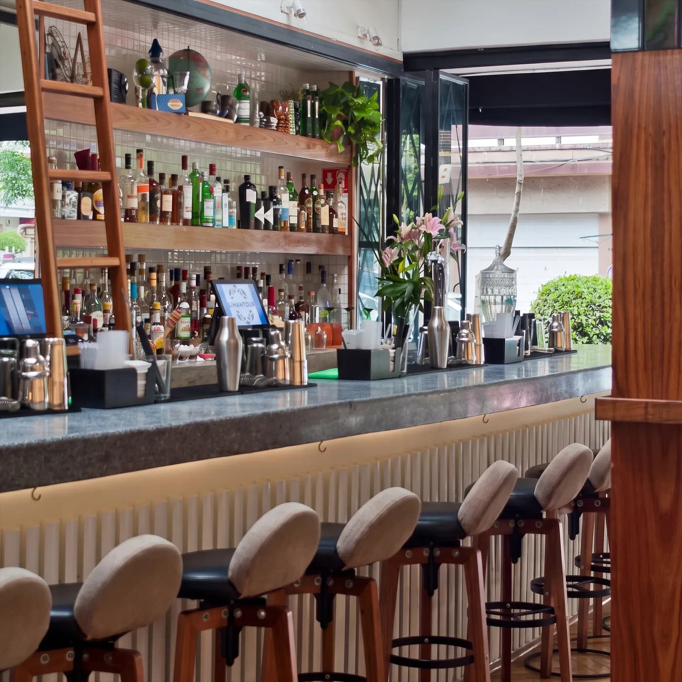 La barra de granito de Limantour Polanco con bancos, cocteleras y azucenas, abierta a la calle