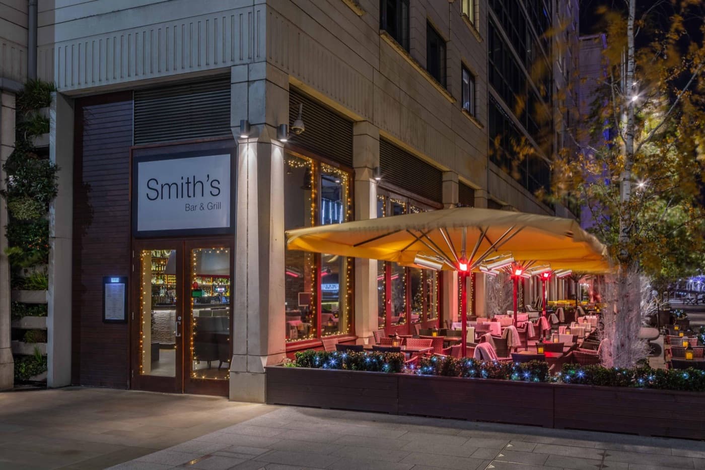Smith's Bar & Grill iluminado de noche en Paddington Central