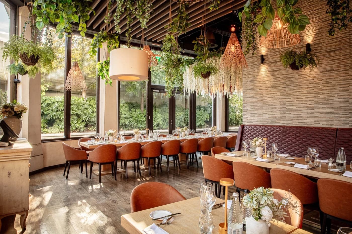 Comedor interior con luz cálida y plantas colgantes en Smith's Bar & Grill