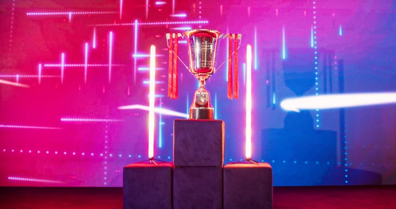 Award trophy on a pedestal under stage lighting with vibrant pink and blue backdrop
